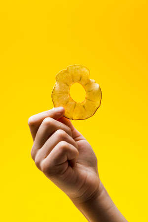 Woman hand take a round dried slice of apple