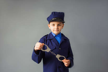 The little boy stand in a police costume and salutedの写真素材