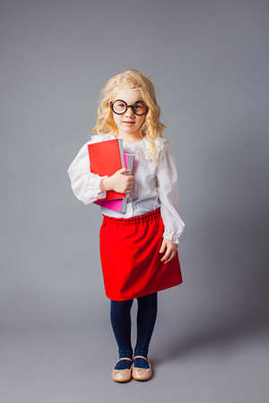 The pretty little girl with glasses dressed in teacher uniformの写真素材