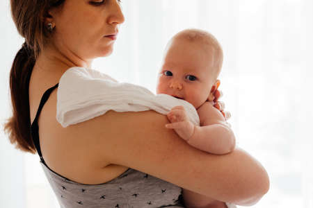 Portrait of young mother holding newborn babyの写真素材