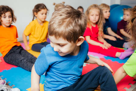 Curious preschool boy enjoying group gymnastic trainingの写真素材