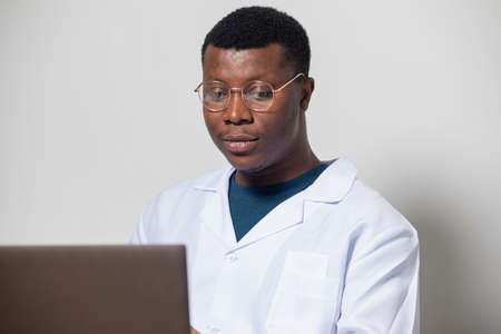 Young doctor gaining new knowledge using laptop