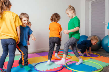 Sport activities with hula hoops at kindergarten