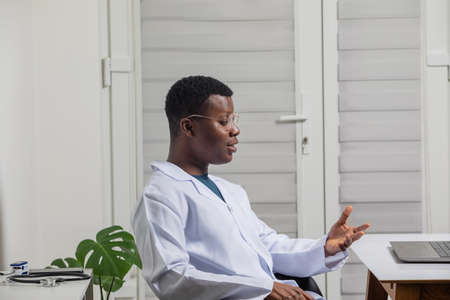 Young doctor gaining new knowledge using laptopの写真素材