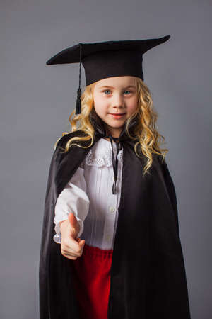 The little girl in a judges costume shows a thumb upの写真素材