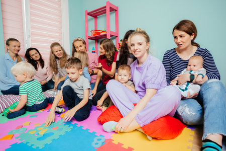Lovely preschool girl at a meeting of mothers with kidsの写真素材