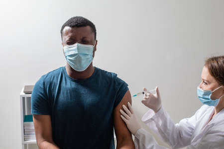 Vaccination during covid pandemic, young nurse making injection.の写真素材