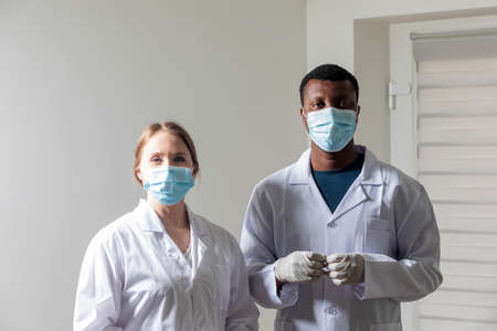 Diverse male and female doctors in white medical masksの写真素材