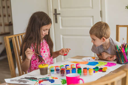 The kids are happy to draw with paints on large paperの写真素材