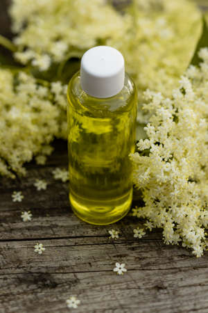 The fragrant elderberry flower with essential oil on a wooden tableの写真素材