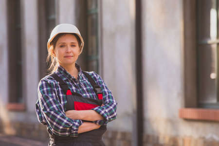Young girl, manual worker posing outdoors with hands folded on chestの写真素材
