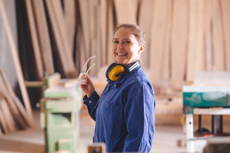 Cheerful female production operator in blue coverallの写真素材