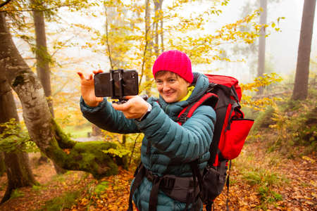 Woman is taking a selfie while hiking in the forest