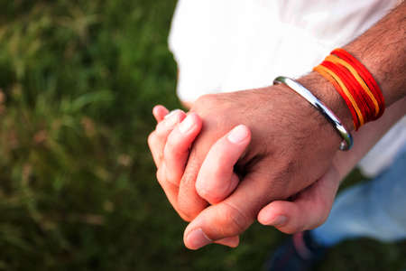 Romantic couple holding hands in summer field at sunsetの写真素材