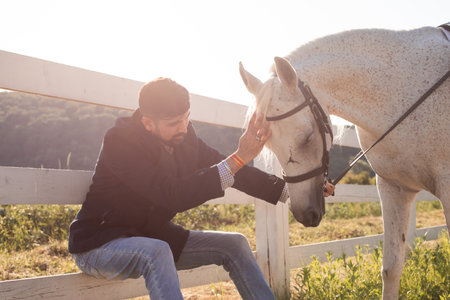 The man is resting with a horse on a ranchの写真素材