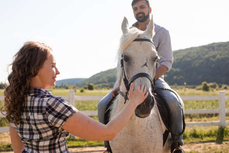The young couple are resting on a horse farmの写真素材