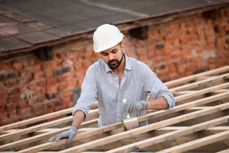 The young builder works on an unfinished roofの写真素材