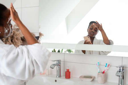 Female beauty blogger shooting video tutorial in bathroomの写真素材