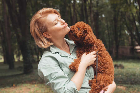Cute yawning dog in female owners arms