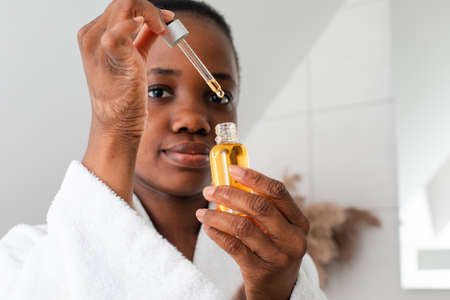 Bottle of serum with drop falling from pipetteの写真素材