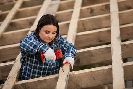 The young woman worker make frame of the roofの写真素材