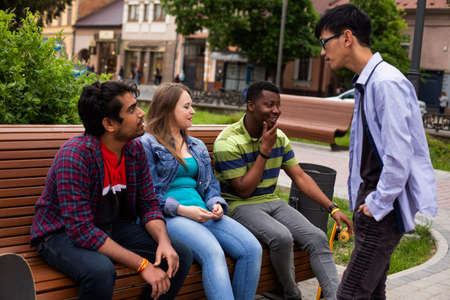 Diverse young men and woman spending free time together at parkの写真素材