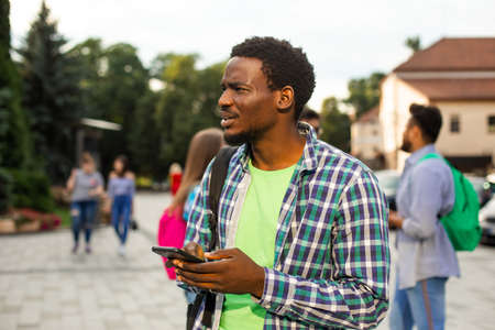 The young african student uses navigation on a smartphoneの写真素材