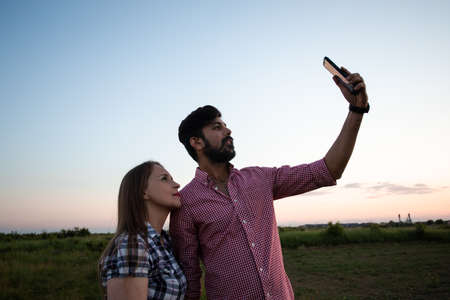 Young girl taking selfie in summer wheat fieldの写真素材