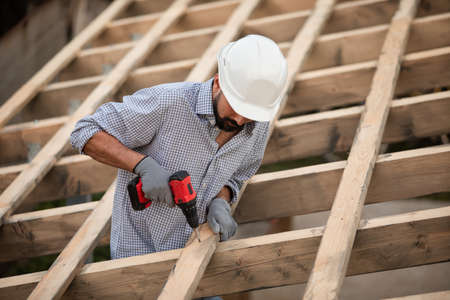 The young builder works on an unfinished roofの写真素材