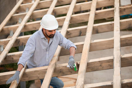 The young builder works on an unfinished roofの写真素材