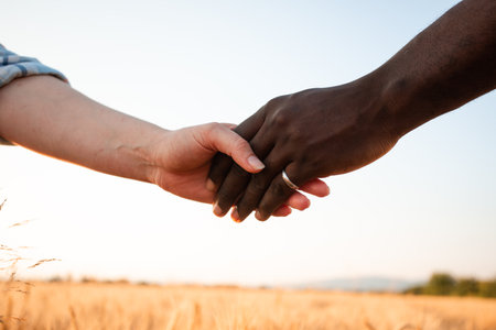 Multiracial relationship and friendsip concept. Two hands holding together.の写真素材