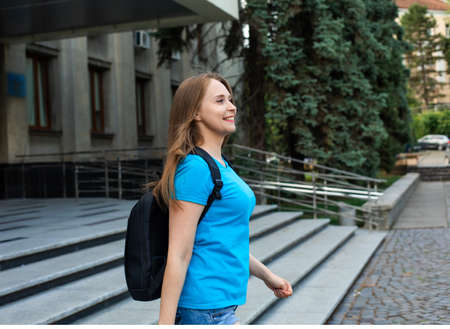 The happy female student with backpack leaves universityの写真素材