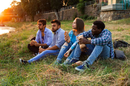The group of young diverse people eating fastfood on natureの写真素材