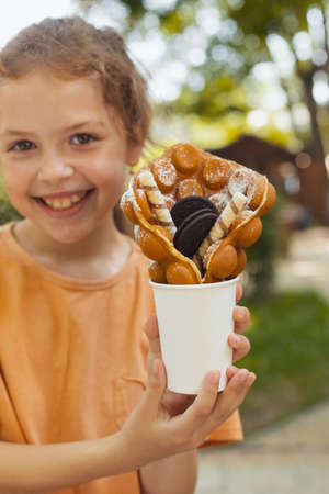 The little girl is enjoying a Belgian waffleの写真素材