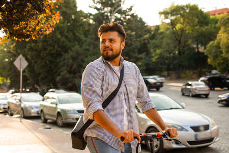 The young man have nice mood while rides an electric scooterの写真素材