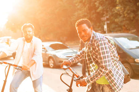 Two adult students stand in the city with electric scootersの写真素材