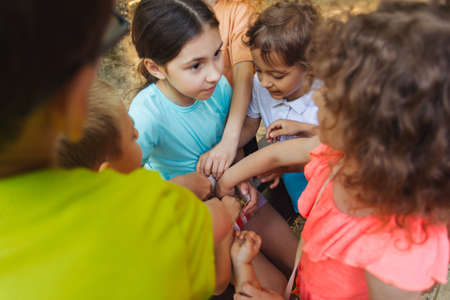 The group of little children shares popcorn in the park
