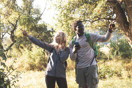 The young couple are looking for a path in the forest