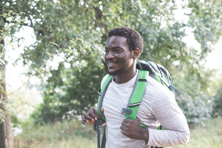The young man with a backpack is hiking in the forestの写真素材