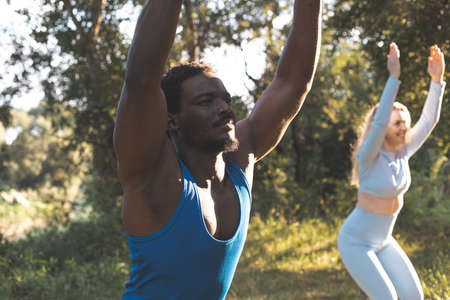 The young diverse people practice yoga in nature