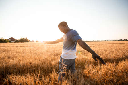 Unspecified man with hands up watching sunsetの写真素材