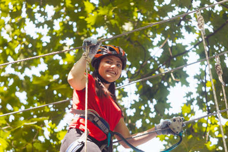 The young female instructor checks outfit in the rope parkの写真素材