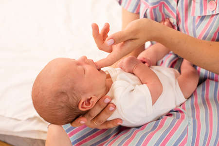 Mom teaches her newborn baby sucking reflexの写真素材