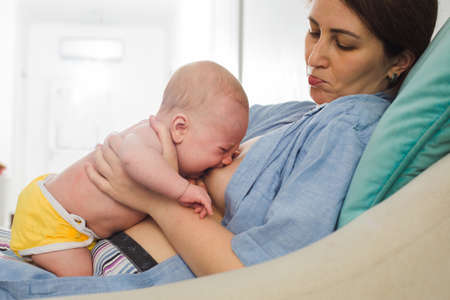 The young mom wants to breastfeed her newborn babyの写真素材