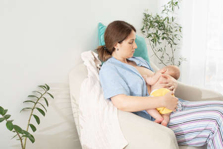 The young mom wants to breastfeed her newborn babyの写真素材