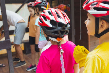 The kids are preparing for a safe climb in the rope parkの写真素材