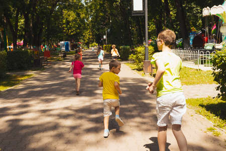 The kids are running on the path in the summer parkの写真素材