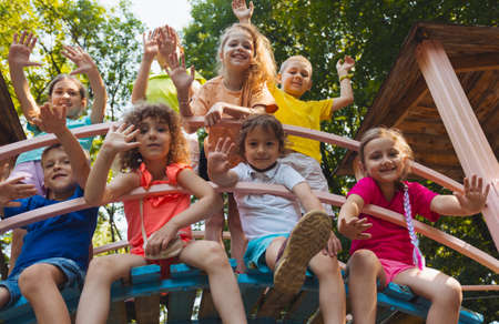 The cheerful kids are resting in a wooden tree houseの写真素材