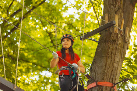 The young female instructor checks outfit in the rope parkの写真素材