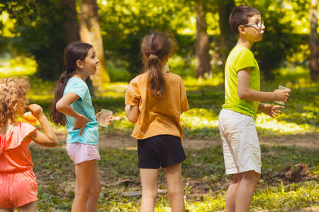 The children have a snack in the park and see somethingの写真素材